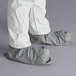 A person wearing white Malt Impact ProMax coveralls with attached boots.