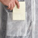 A person holding a note pad in a white Malt Impact lab coat.