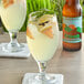 A glass of Casamara Club Como Breezy Mandarina soda with a slice of orange and ice.