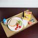 A Cambro earthen gold dietary tray with a sandwich, chips, and a blue drink on it.