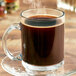 A glass mug filled with Ellis Mezzaroma Guatemalan French Roast coffee with steam rising from it.