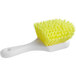 A close up of a yellow Lavex floating utility brush with a white handle.