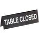 A close-up of a black Cal-Mil "Table Closed" sign.