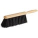 A close up of a black Lavex Tampico counter brush with a wooden handle.