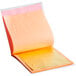 A yellow and pink paper with a 24K edible gold leaf sheet on a white surface.