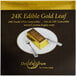 A package of 24k edible gold leaf sheets with a gold bar and silverware on it.