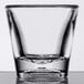 A clear plastic shot glass with a clear bottom on a table.