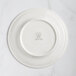 A white RAK Porcelain flat plate with an embossed floral design.