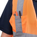 A man wearing a Cordova orange high visibility safety vest with pockets.