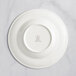 A white RAK Porcelain deep plate with an embossed crown on the rim.