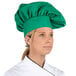 A woman wearing a green Intedge chef hat.