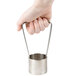 A hand using the Nemco Large Core Cutter with a metal container and a metal handle.