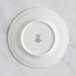 A RAK Porcelain ivory flat plate with an embossed crown on the rim.