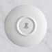 A white RAK Porcelain saucer with an ivory embossed design.