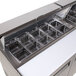 A Turbo Air refrigerated sandwich prep table with a stainless steel counter top and trays.