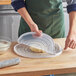 A person using an OXO silicone dough rolling bag to roll out dough on a cutting board.