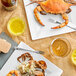 A plate of Chesapeake Blue Crab and a fork on a table with drinks.