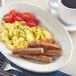 A plate of scrambled eggs and Regal Original breakfast sausages.