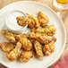 A plate of Regal Garlic and Herb chicken wings with white sauce.