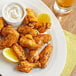 A plate of chicken wings with lemon wedges and Regal Seafood Wing Rub.