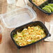A table with two Choice clear plastic containers of food, one with noodles and shrimp and the other with a clear plastic lid.