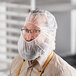 A man wearing a Malt Impact white polypropylene hood over a beard.