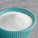 A bowl of Domino granulated sugar on a table.