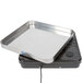 A rectangular stainless steel tray on a black surface.