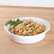 A Pactiv Newspring white plastic bowl of rice with vegetables.