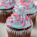 A cupcake with blue and pink frosting and Bake-Stable Pink Sprinkles.