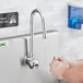 A person washing their hands with a Waterloo wall mount hands-free sensor faucet.