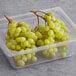 A plastic container of green seedless grapes.