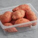 A plastic container filled with Fresh Sweet Potatoes.