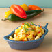 A blue HS Inc. Jalanino salsa server filled with pineapple salsa on a counter.