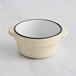 A white stoneware sauce cup with a black rim.