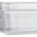 A clear translucent plastic food pan with measurements on the side.