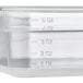 A clear plastic Vigor food pan with measurements on it.