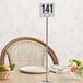 A Tablecraft chrome-plated menu / card holder with a table number on it.