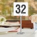A Tablecraft plastic table number card on a table.