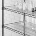 A clear Regency shelf liner on a shelf with white vases and glasses.