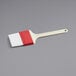 A white and red Choice pastry and basting brush with a plastic handle.