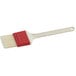 A natural bristle pastry and basting brush with a plastic handle.