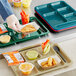 A black Choice 6 compartment tray with food and a fork on it.