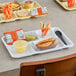 A white Choice melamine compartment tray with food in it on a table.
