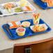 A Choice blue melamine tray with 6 compartments holding food, a cup, and a bowl.