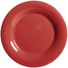 A close-up of a cranberry red plate with a wide rim.