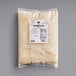 A package of Follow Your Heart Dairy-Free Vegan Grated Parmesan Cheese on a gray surface.