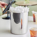 A silver Choice stainless steel bucket holding white paper straws on a table.