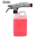 A DEMA One medium flow spray and foamer dispenser with a hose and sprayer spraying pink liquid.