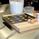 A Vollrath rimless aluminum cookie sheet with cookies on it on a counter next to eggs and flour.